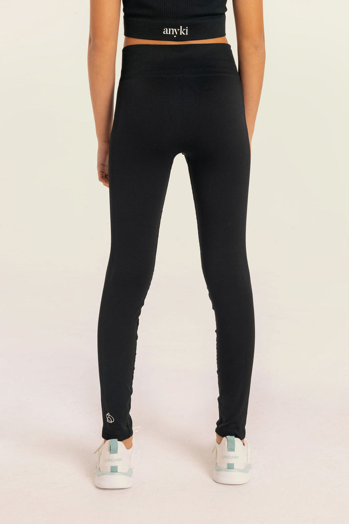Black seamless leggings with ribbed details for girls with high waist. Available in size 6-14 years old. Designed in Sweden and made of sustainable materials. 