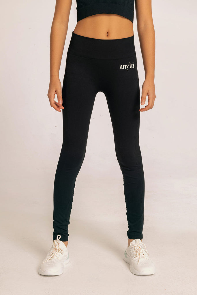 Black seamless leggings with ribbed details for girls with high waist. Available in size 6-14 years old. Designed in Sweden and made of sustainable materials. 