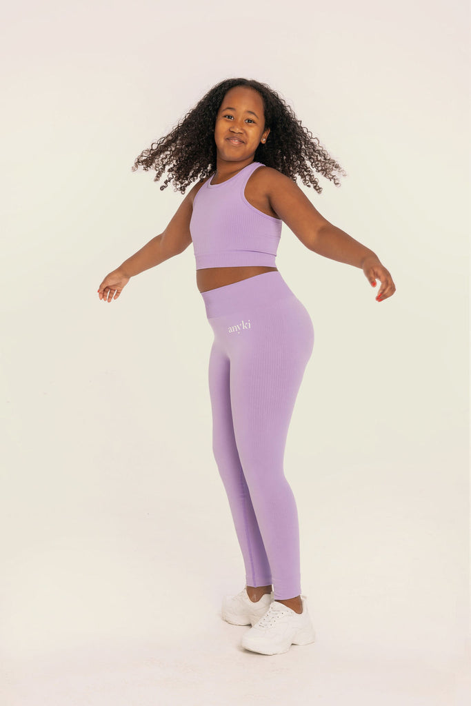 Purple seamless leggings with ribbed details for girls with high waist. Available in size 6-14 years old. Designed in Sweden and made of sustainable materials. Perfect for dancing or other sports.
