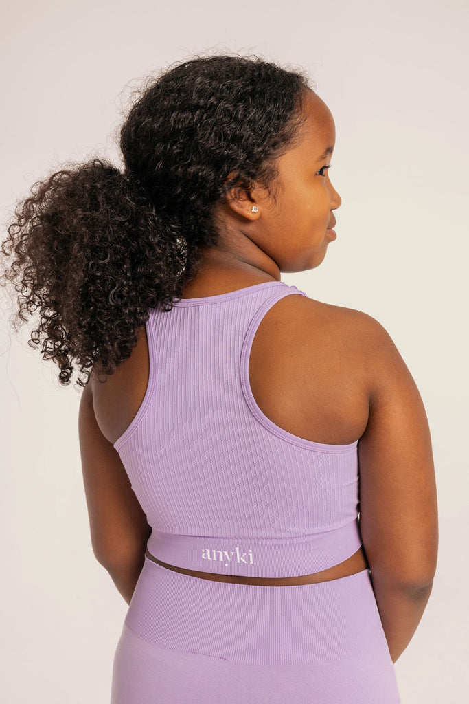 Purple seamless top with ribbed details. Available in size 6-14 years old. Designed in Sweden and made of sustainable materials. Perfect for gymnastics or other sports. 